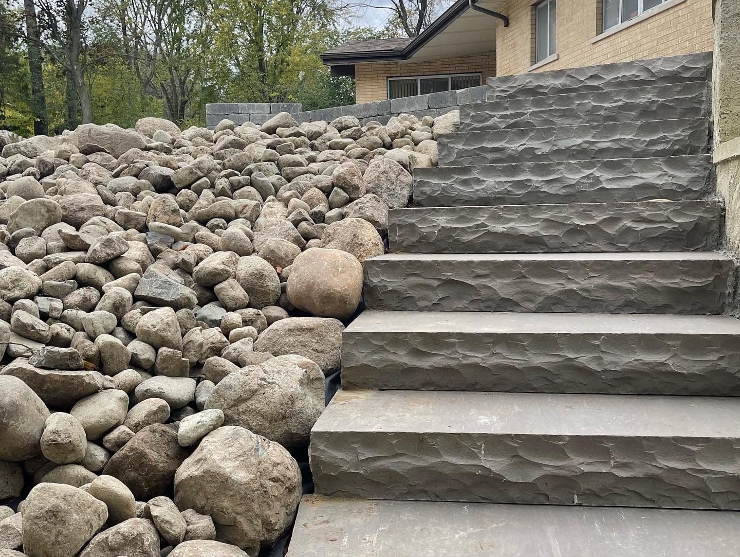Enhancing Outdoor Spaces with Boulder Retaining Walls and Limestone Steps